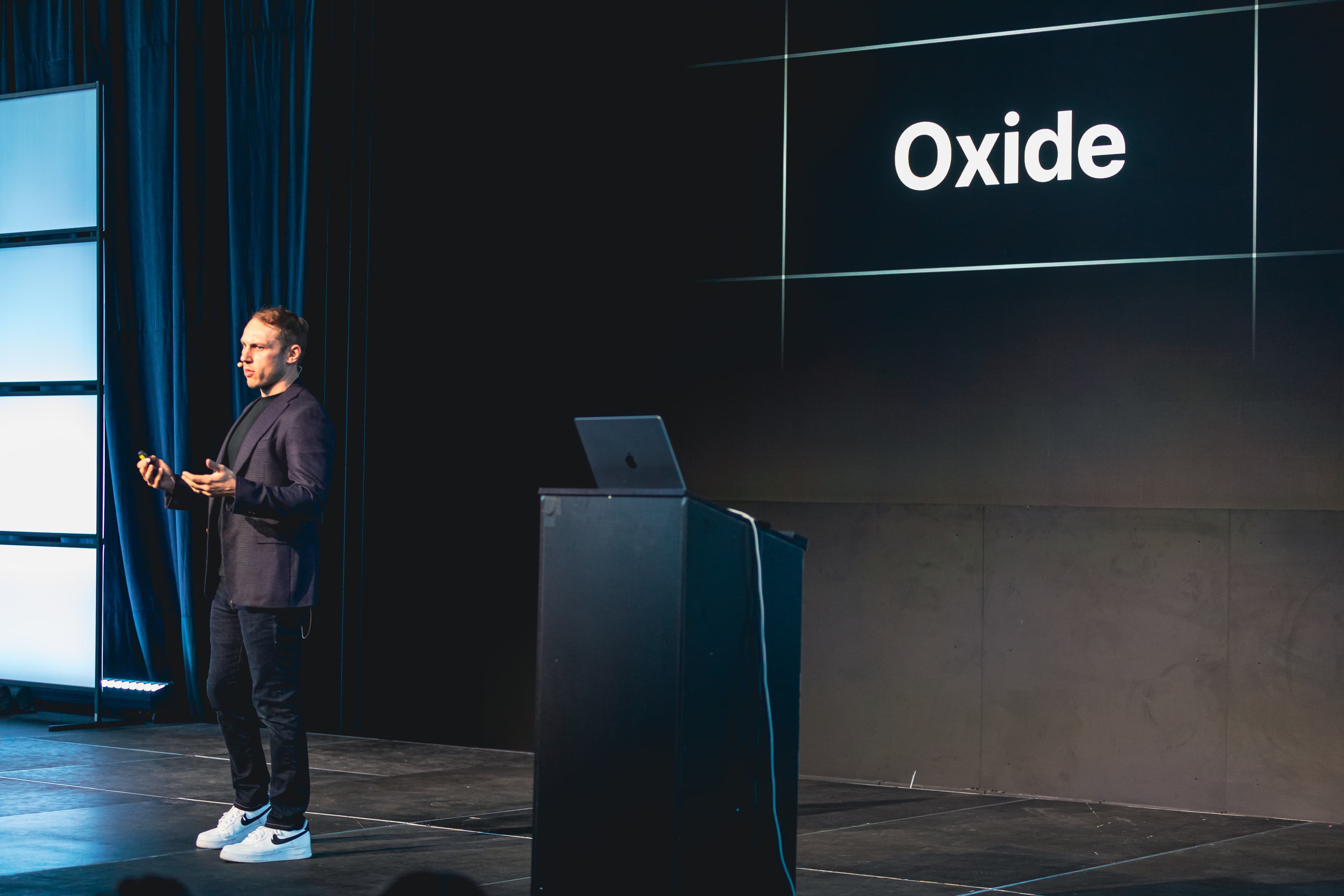 Adam Wathan on stage in front of a slide that says Oxide